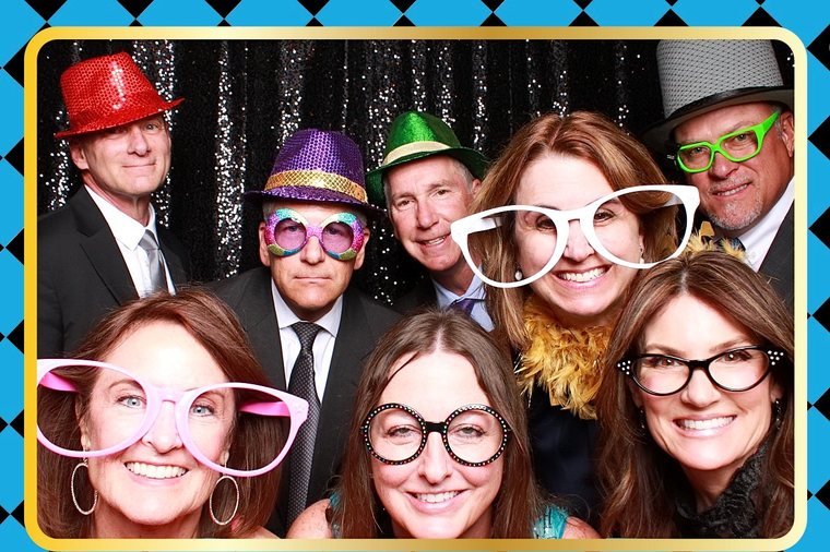 Guests posing with oversized novelty glasses at Child Advocates of Fort Bend's 'Through the Looking Glass' gala, sponsored by KW Southwest